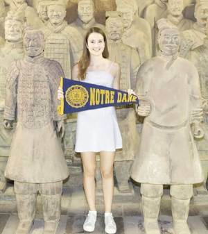 Student posing in front of terracotta solider statues in China